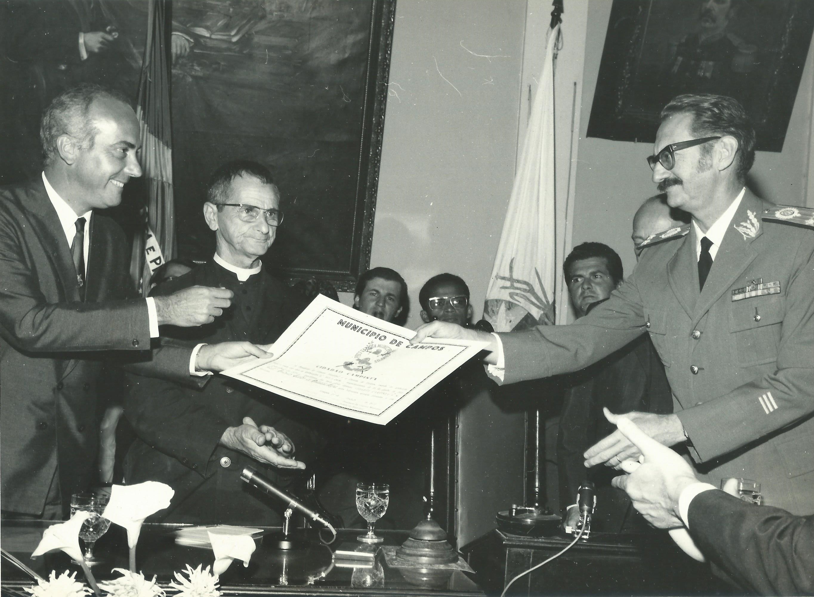 Rockefeller Felisberto e Padre Antônio do Rosário, outorgando um militar, com uma de suas comendas